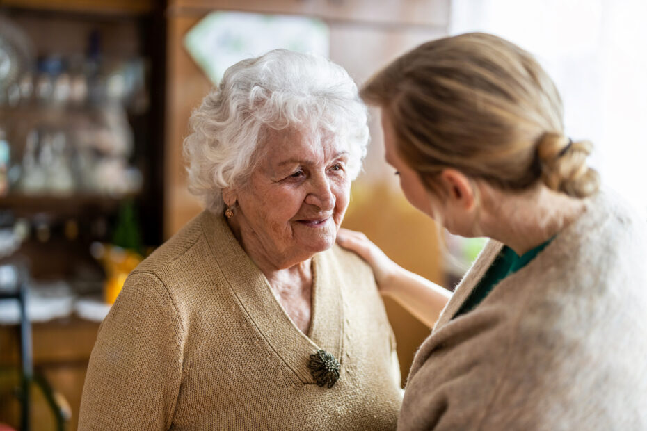 Zwei Frauen sitzen zu Hause im Gespräch miteinander.